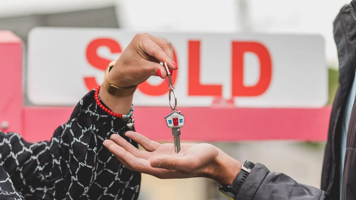 agent immobilier indépendant : une main tient une clé de maison remise à l'acquéreur