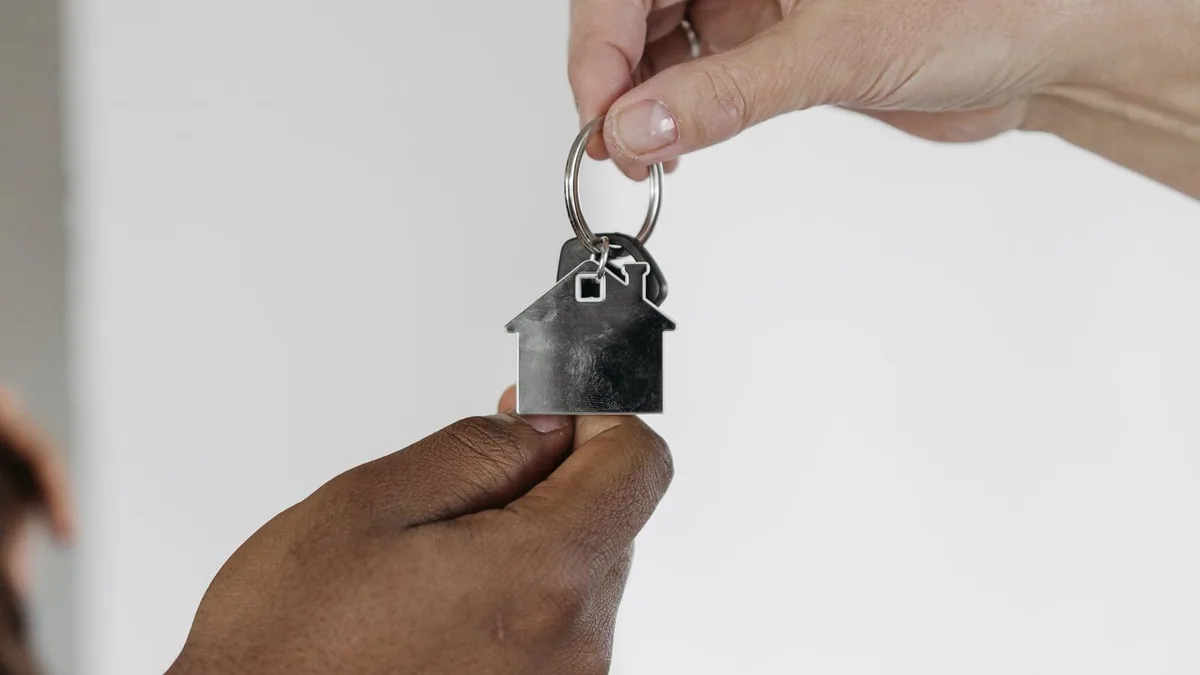 assurance Airbnb : remise de clés avec un porte-clés en forme de maison