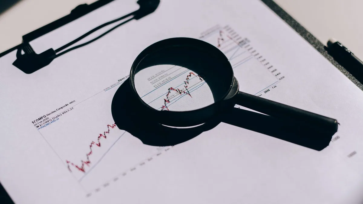 Pourquoi faire un audit SEO : loupe posée sur un rapport d’analyse
