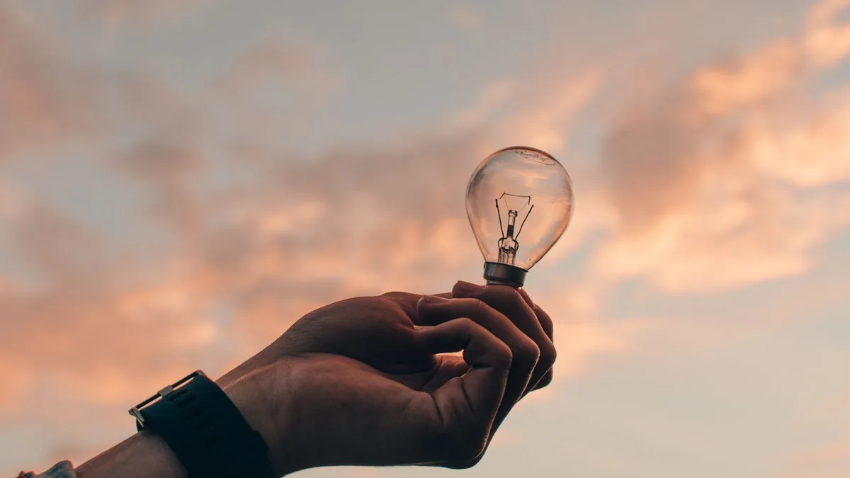 Augmenter sa visibilité sur internet : main tenant une ampoule, symbole d'une idée nouvelle