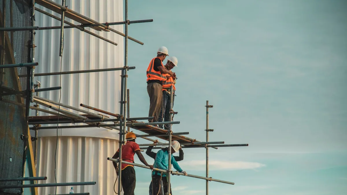 autoliquidation TVA : ouvriers d'une entreprise sous-traitante sur un échafaudage de chantier