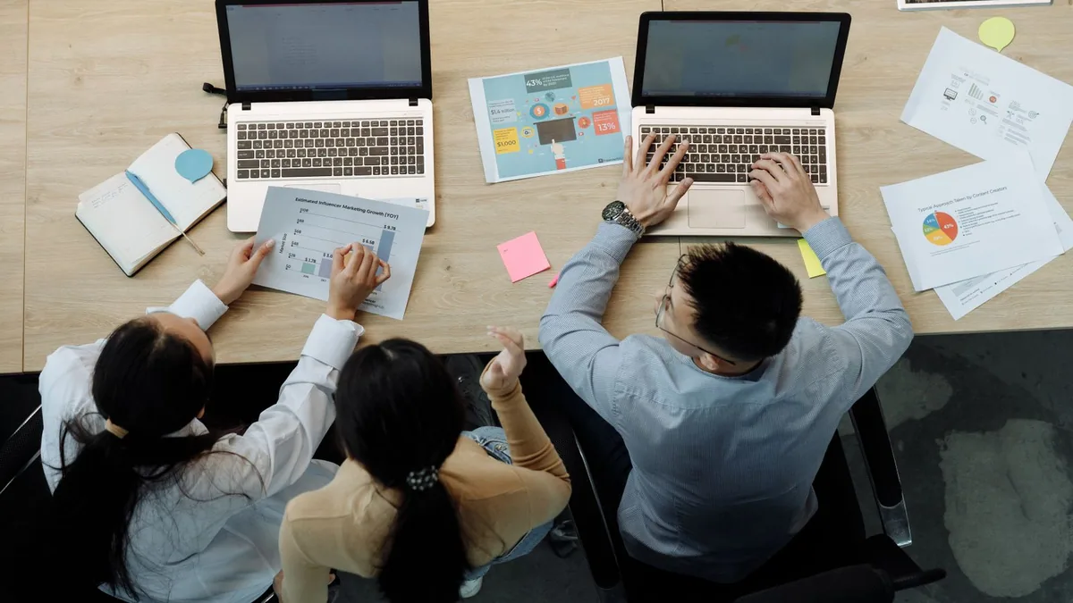 avantages saas : collaborateurs analysant des graphiques sur leurs ordinateurs au bureau