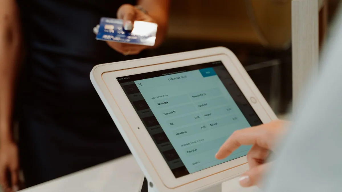 Avantages de WooCommerce : commerçant enregistrant une commande sur un terminal de caisse