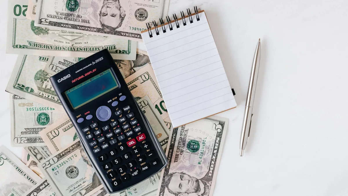 besoin en fonds de roulement : calculatrice et bloc-notes posés sur une pile de factures