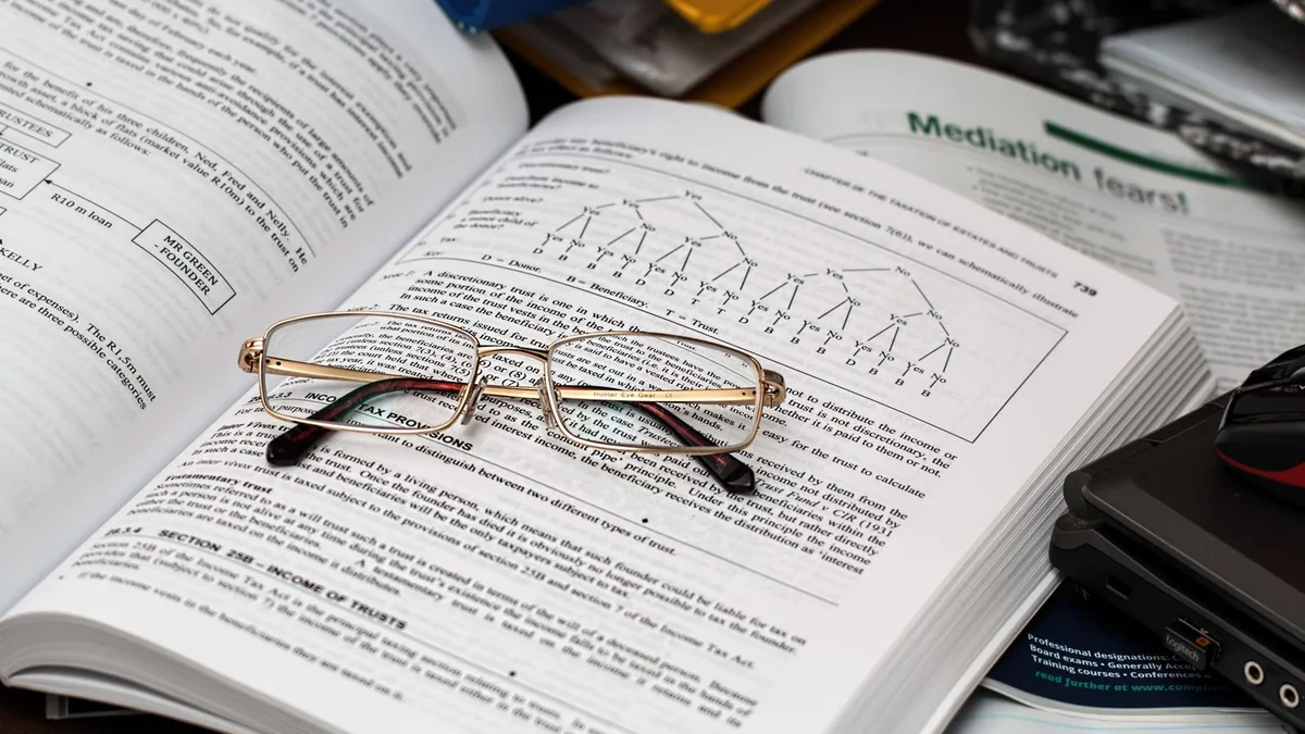 bilan comptable : lunettes posées sur un registre de comptabilité ouvert
