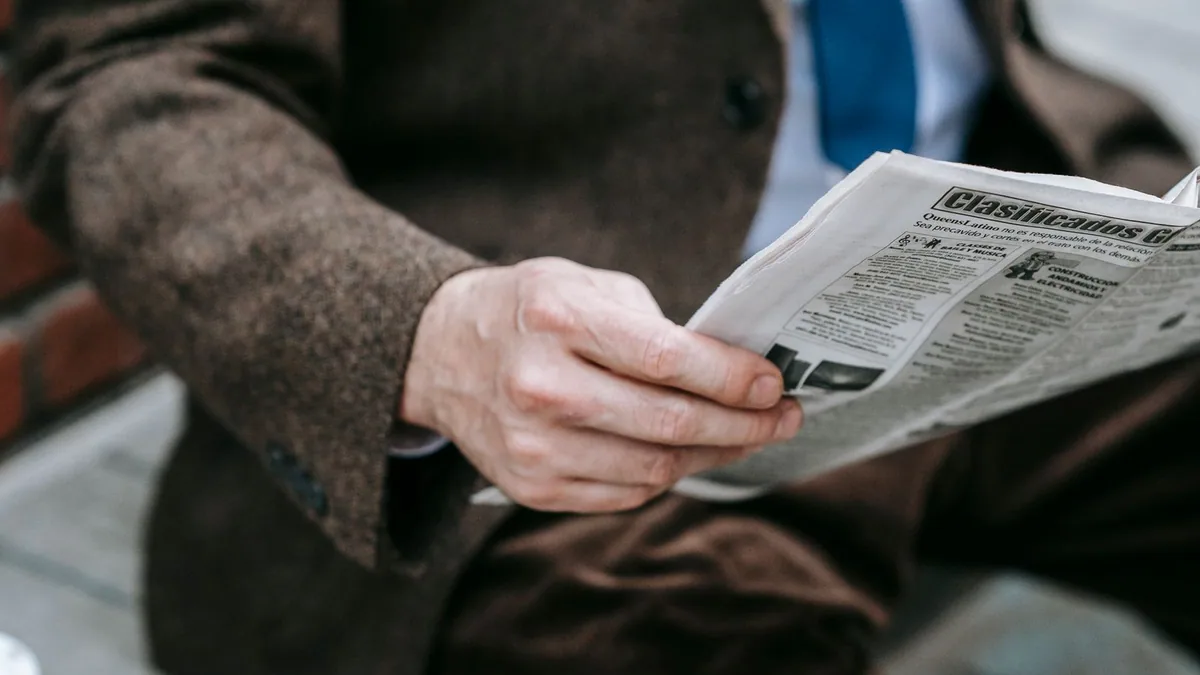 BODACC : personne tenant un journal ouvert pour lire les annonces