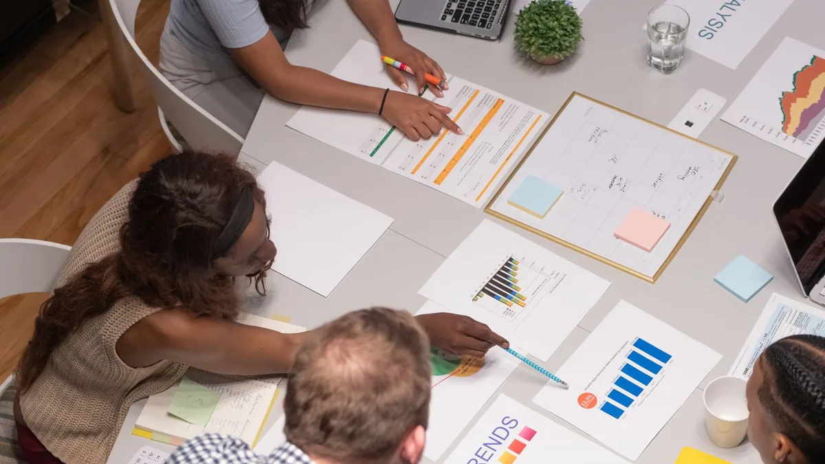 business plan : des entrepreneurs planifient leur projet autour de documents et de graphiques