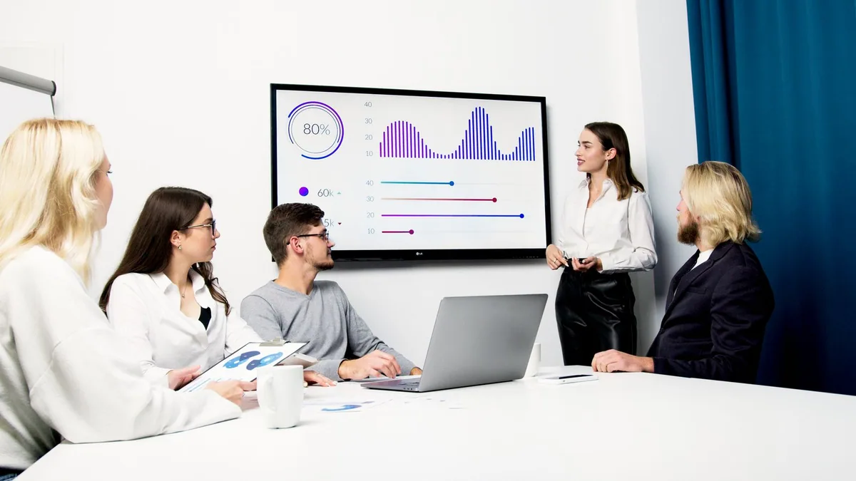 business review : une responsable présente un bilan chiffré à son client en réunion