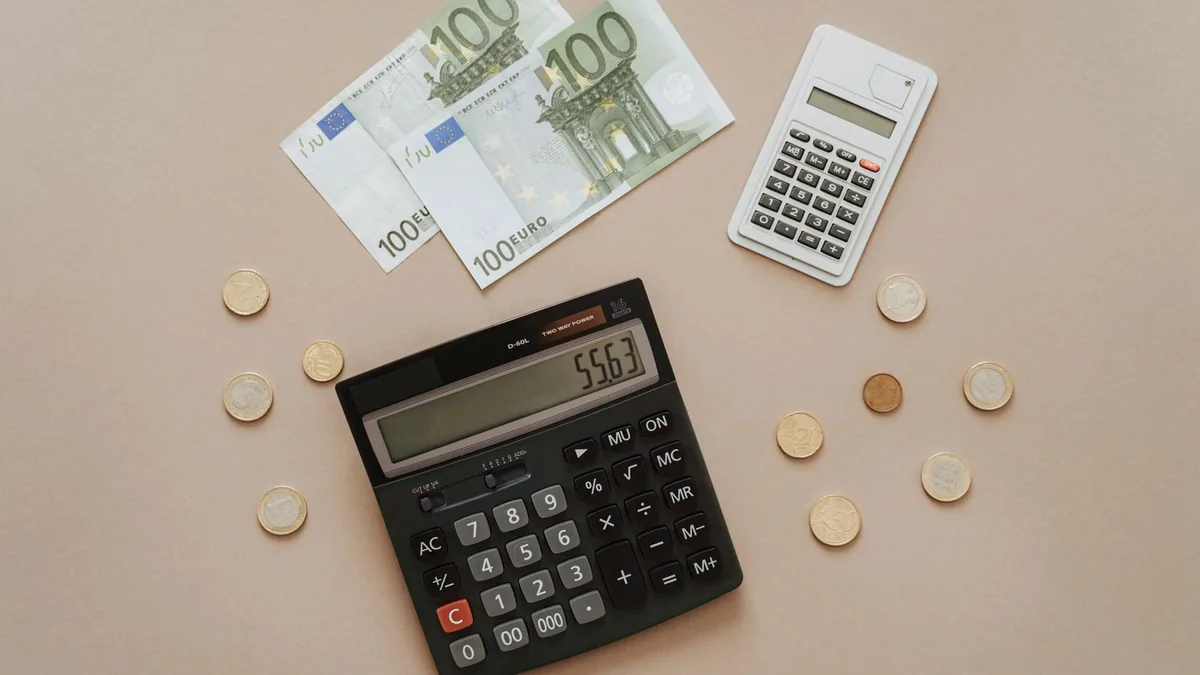 calcul impôt sur les sociétés : calculatrice et pièces de monnaie pour estimer l'impôt