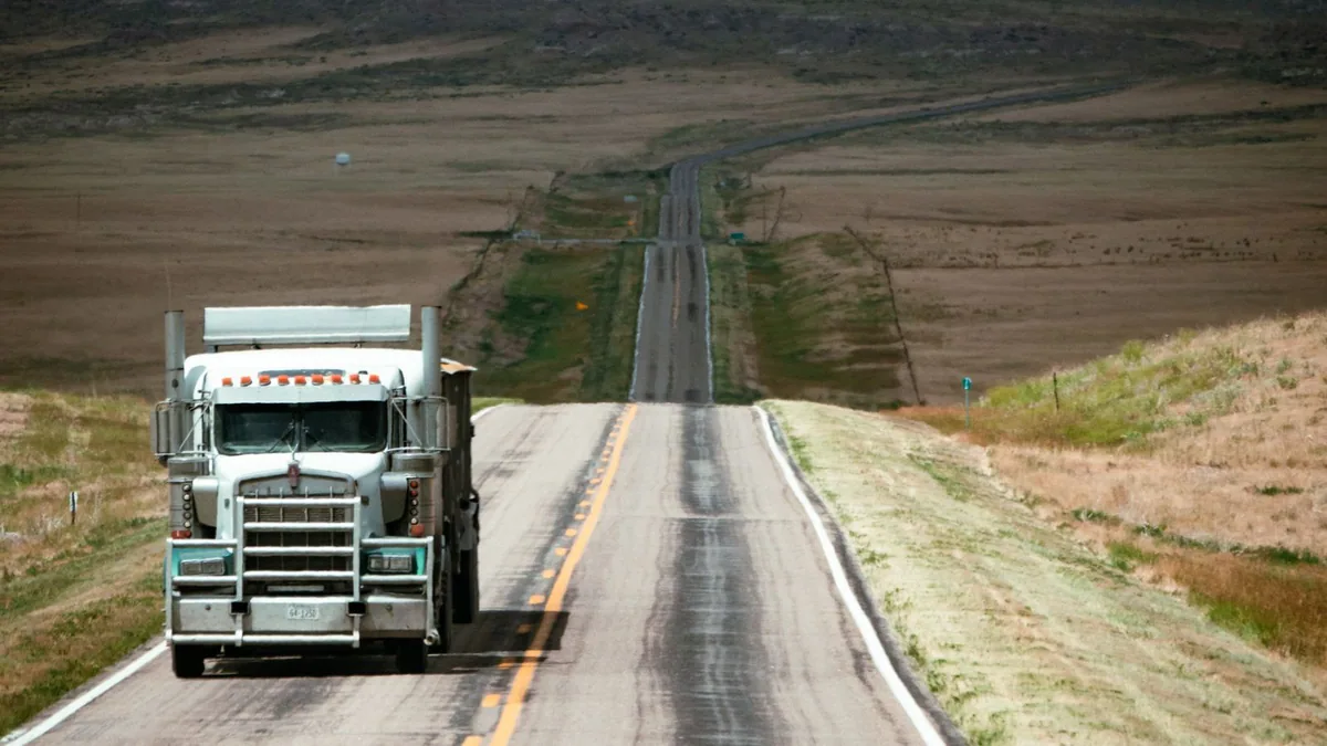 Capacité de transport : camion blanc sur une route de campagne près d'une colline