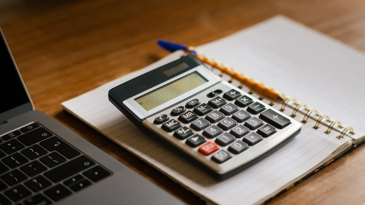 chiffre d'affaires et bénéfice : billets, calculatrice et lunettes sur le bureau d'un comptable