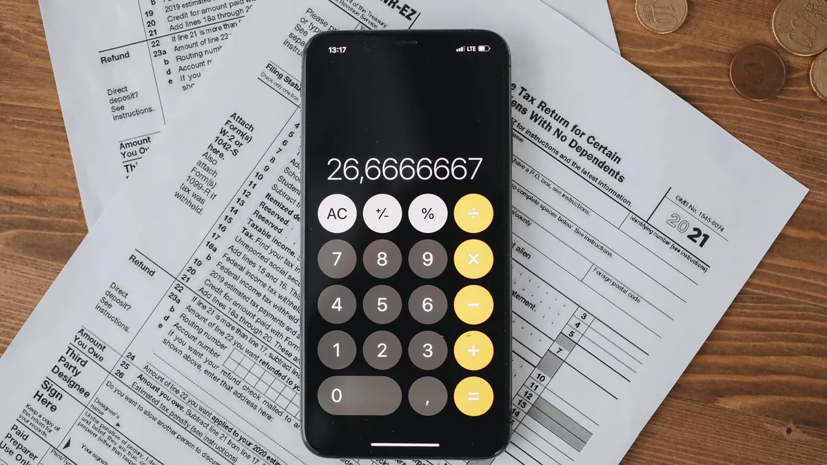 CICE : formulaires fiscaux et calculatrice posés sur une table en bois