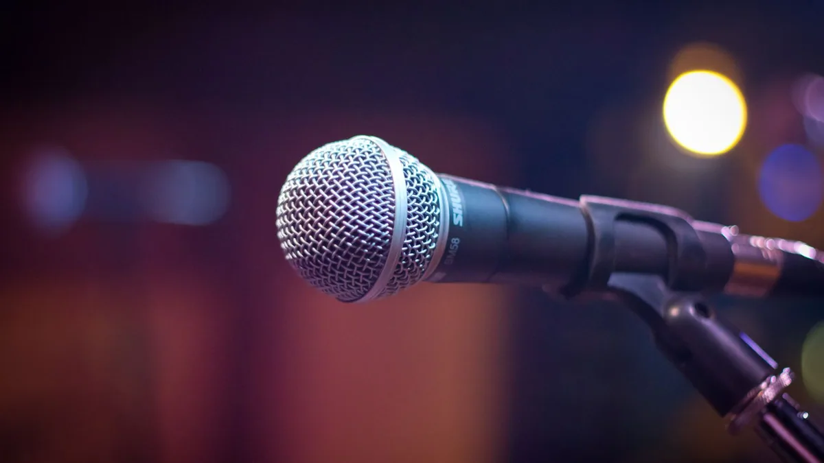 communication audiovisuelle : microphone sur pied devant des lumières de scène