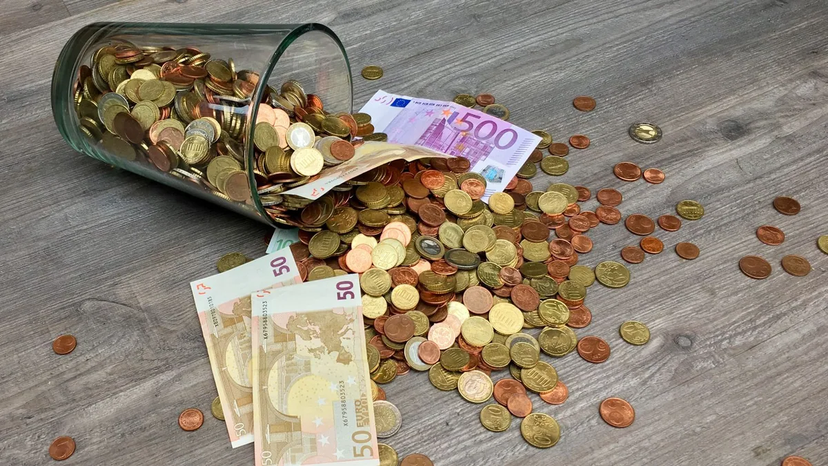 Compte courant d'associé : billets et pièces en euros sur une surface en bois