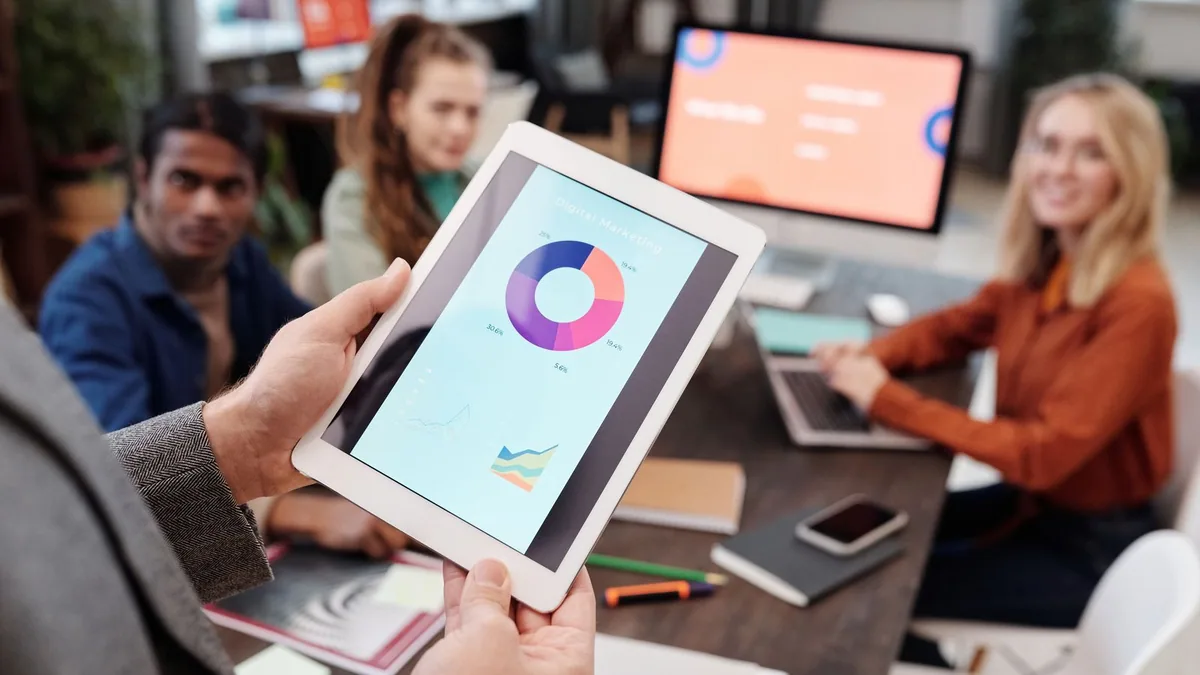 Consultant SEA : tablette affichant un graphique de répartition d'une campagne de marketing digital