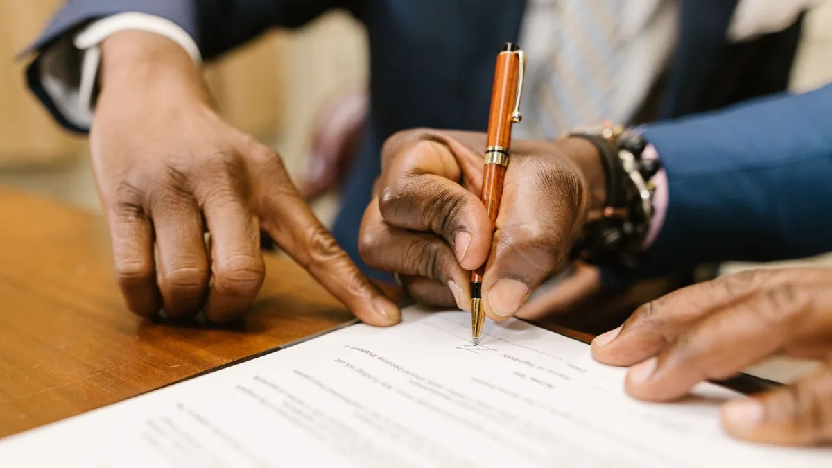 définition société : une personne remplit un contrat, stylo en main