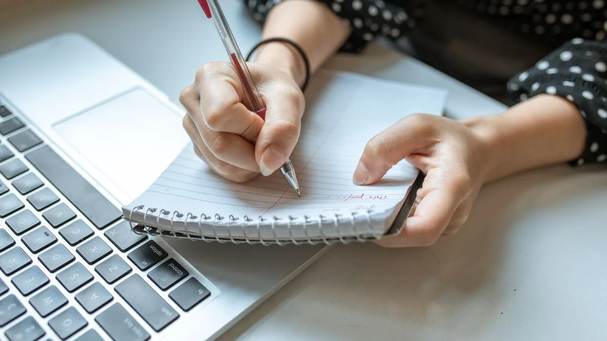 Devenir freelance SEO : prise de notes dans un carnet pendant une formation