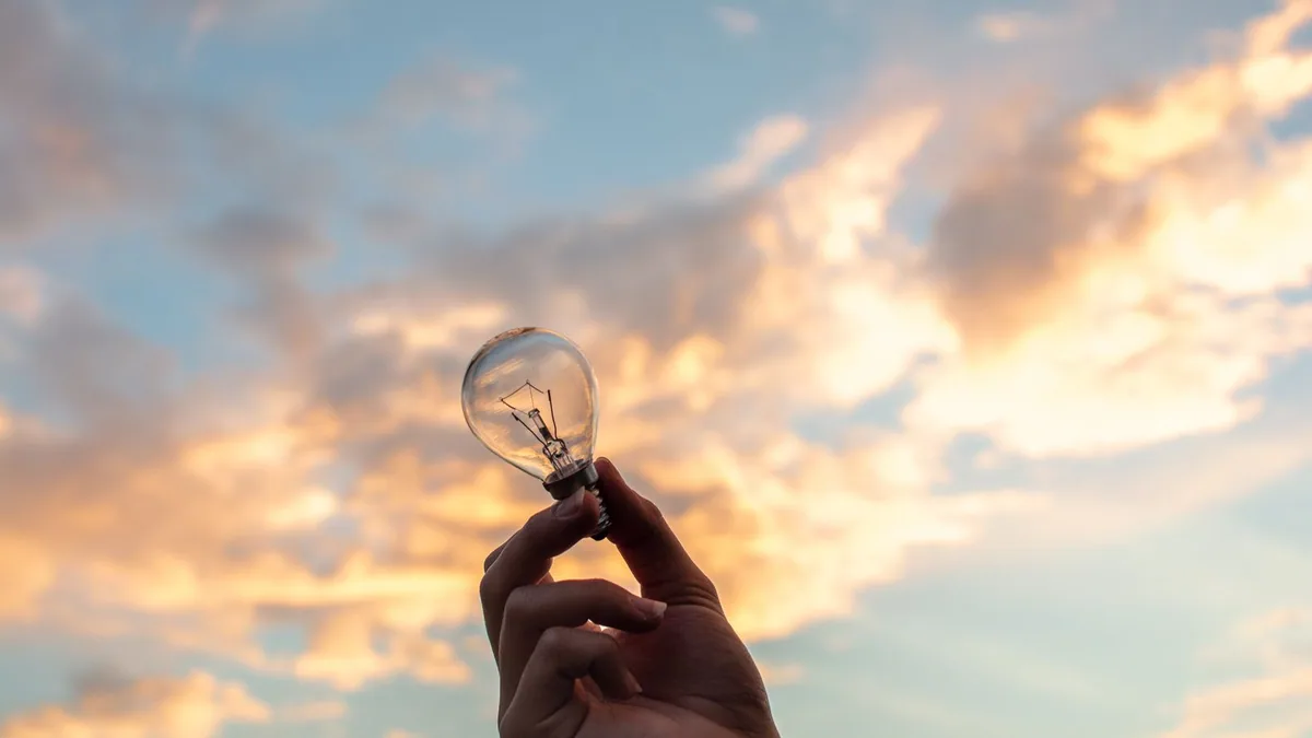 Devenir freelance SEO : main tenant une ampoule, image d'une offre de services innovante