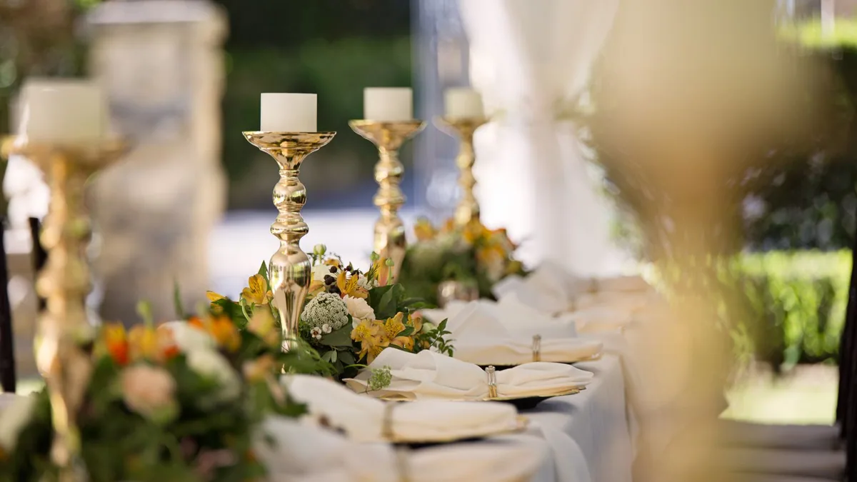 devenir wedding planner : table de réception de mariage dressée avec chandeliers et décoration