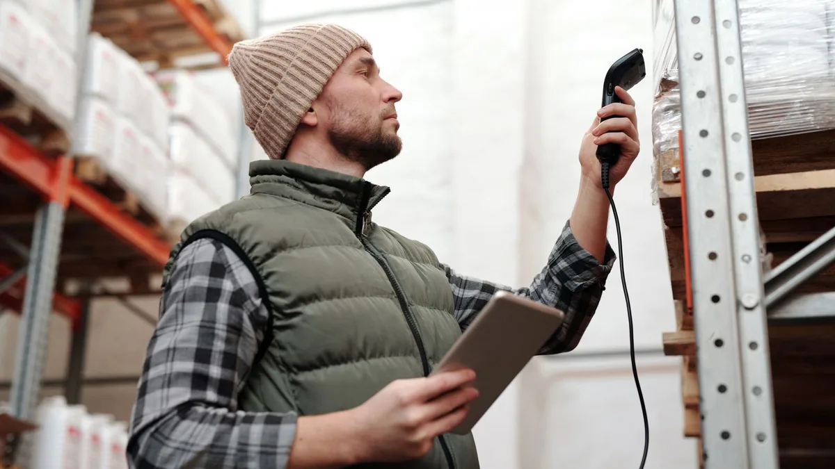 digitalisation transport : un préparateur scanne des colis dans un entrepôt logistique