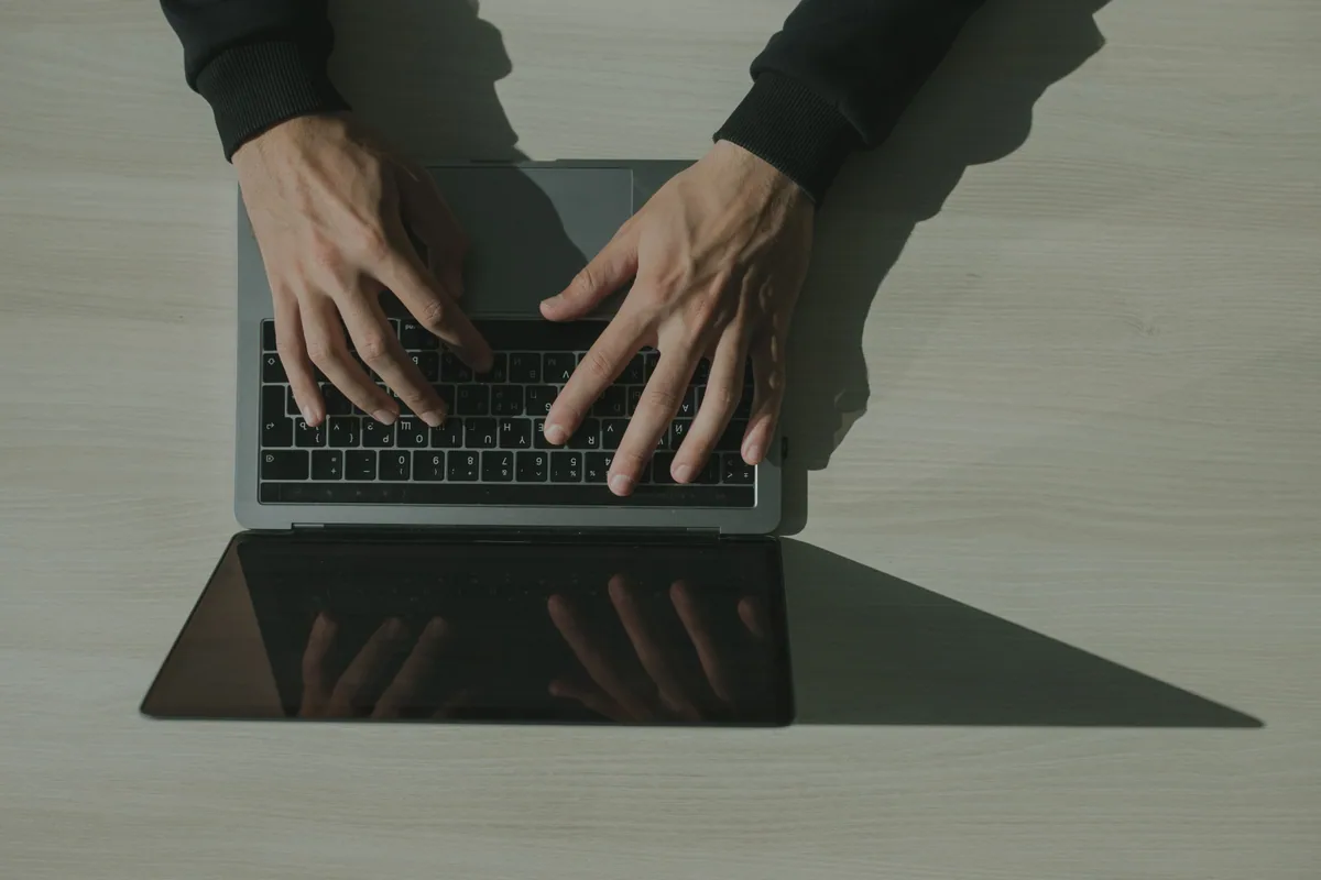Enregistrer un nom de domaine : mains tapant sur le clavier d'un ordinateur portable