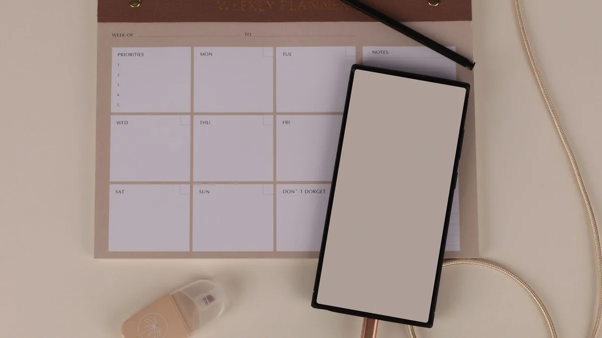 gestion du temps : bureau avec planning hebdomadaire ouvert et outils d'organisation
