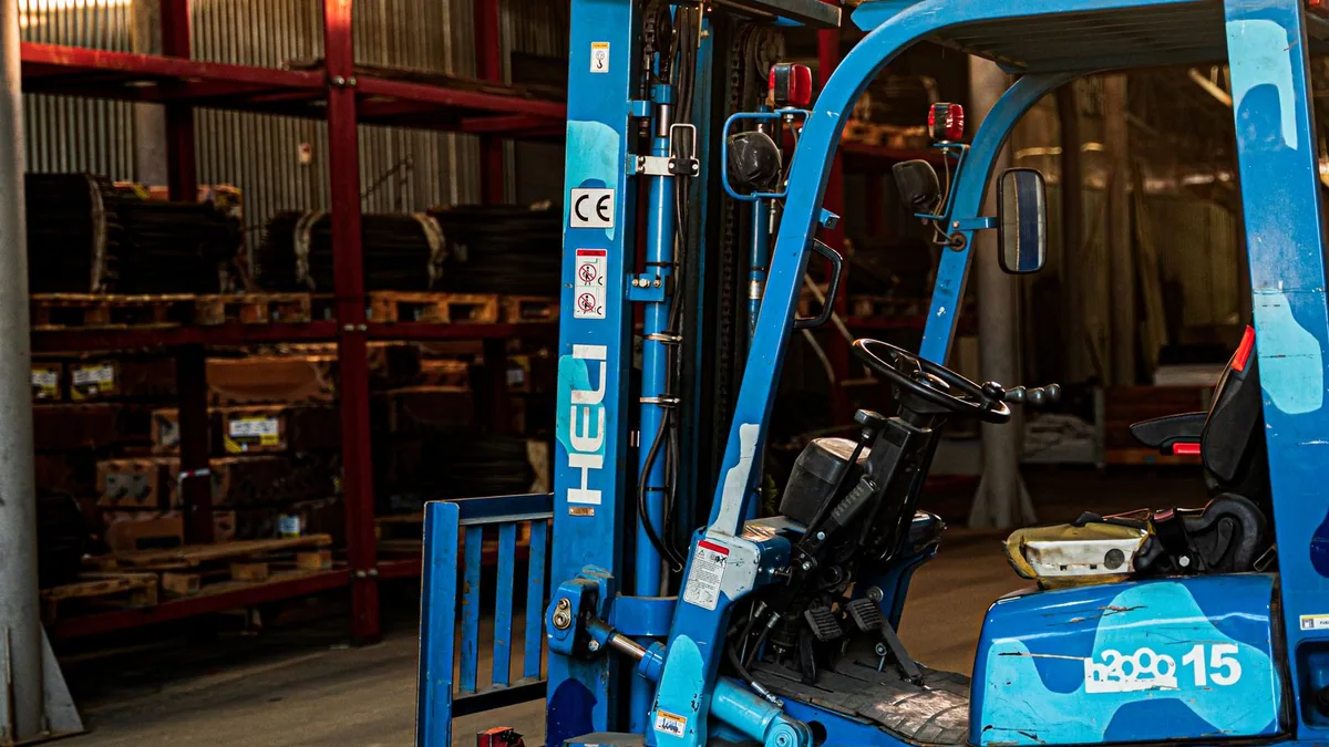 livraison B2B : chariot élévateur dans un entrepôt préparant des palettes à expédier