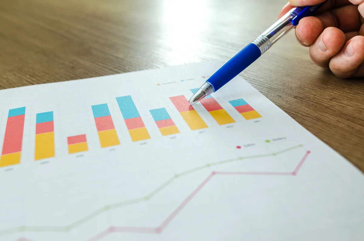 marketing mix : main pointant des graphiques colorés avec un stylo bleu