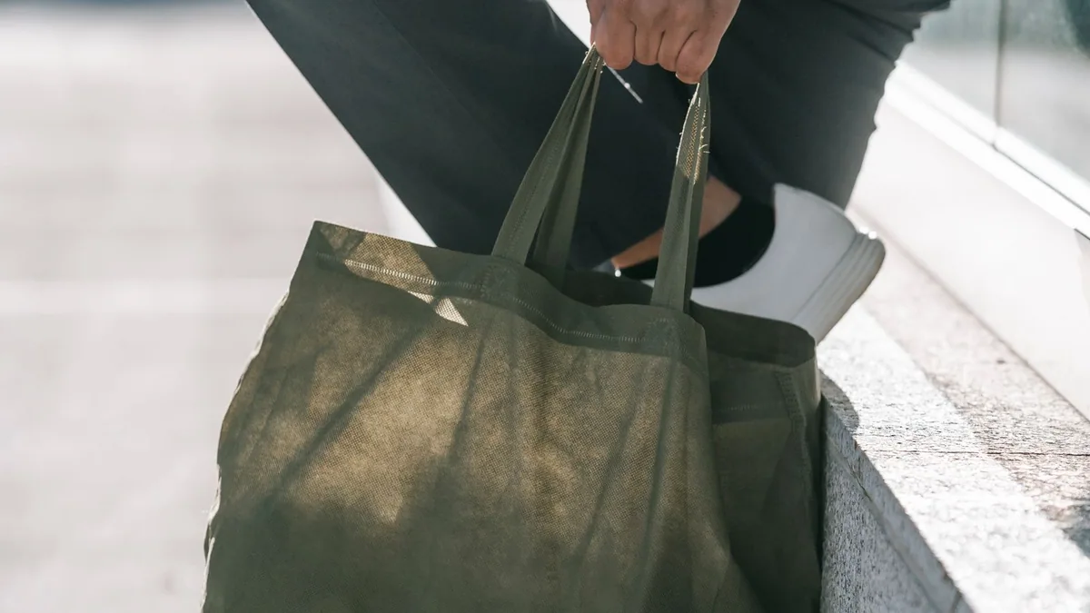 marketing offline : passant portant un sac en toile réutilisable dans la rue
