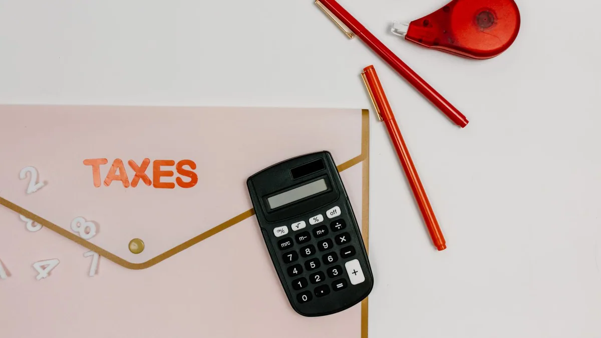 masse salariale : calculatrice et stylos rouges pour vérifier un budget du personnel