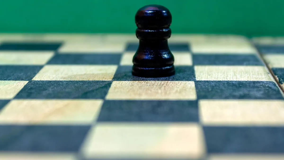 matrice ansoff : pion d'échecs sur un échiquier en bois devant un fond vert