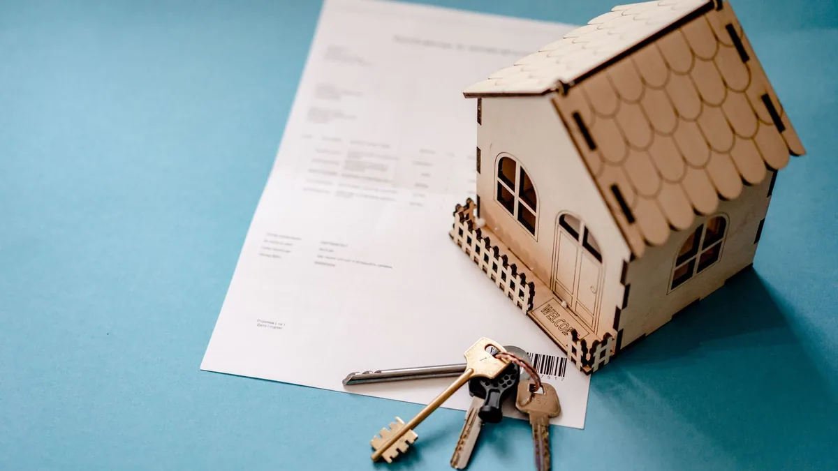 micro foncier : maquette de maison, clés et contrat de location posés sur une table