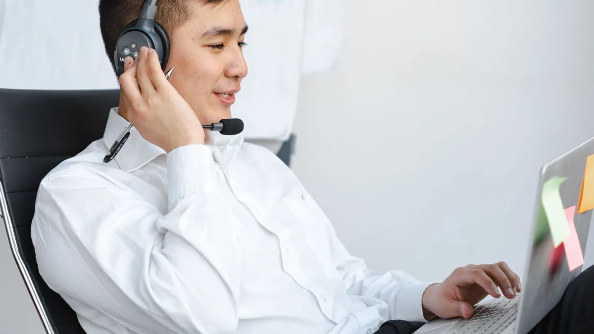 odigo : conseiller client avec un casque répondant à un appel sur son ordinateur portable
