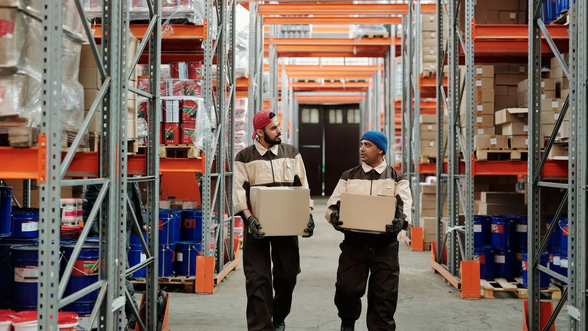 opérations logistiques : préparateurs transportant des cartons dans un entrepôt