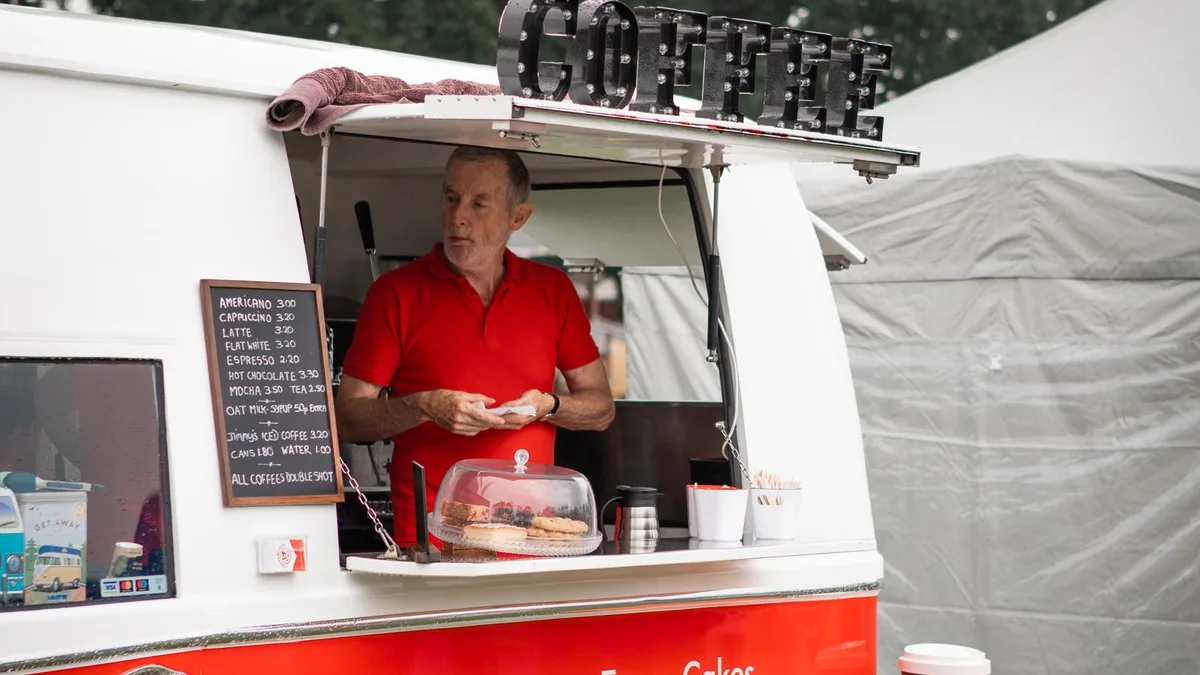 ouvrir un food truck : un commerçant prépare des commandes dans son camion