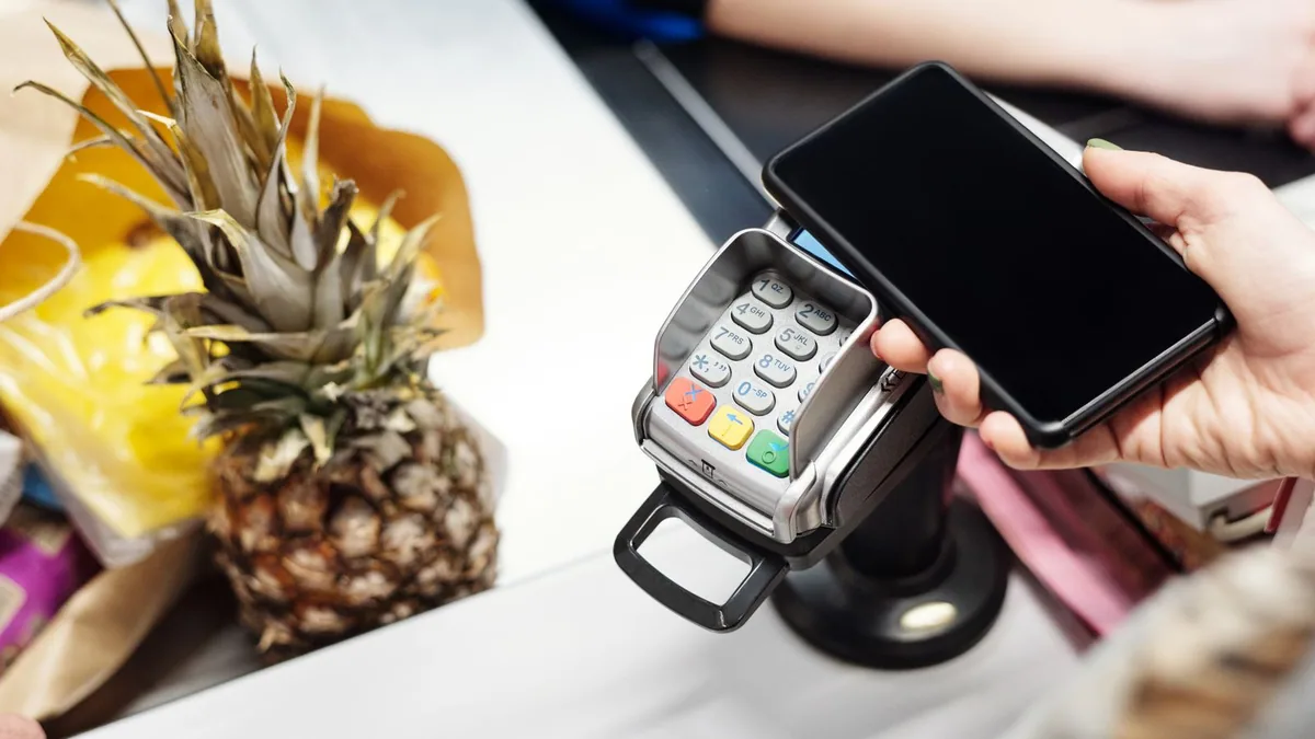 Plaque avis Google : client approchant son smartphone d'un support sans contact