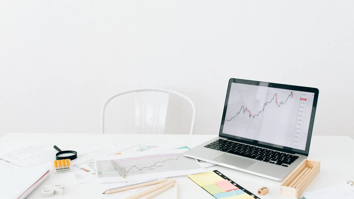 Prévisionnel financier : ordinateur portable, documents et notes adhésives pour préparer les tableaux