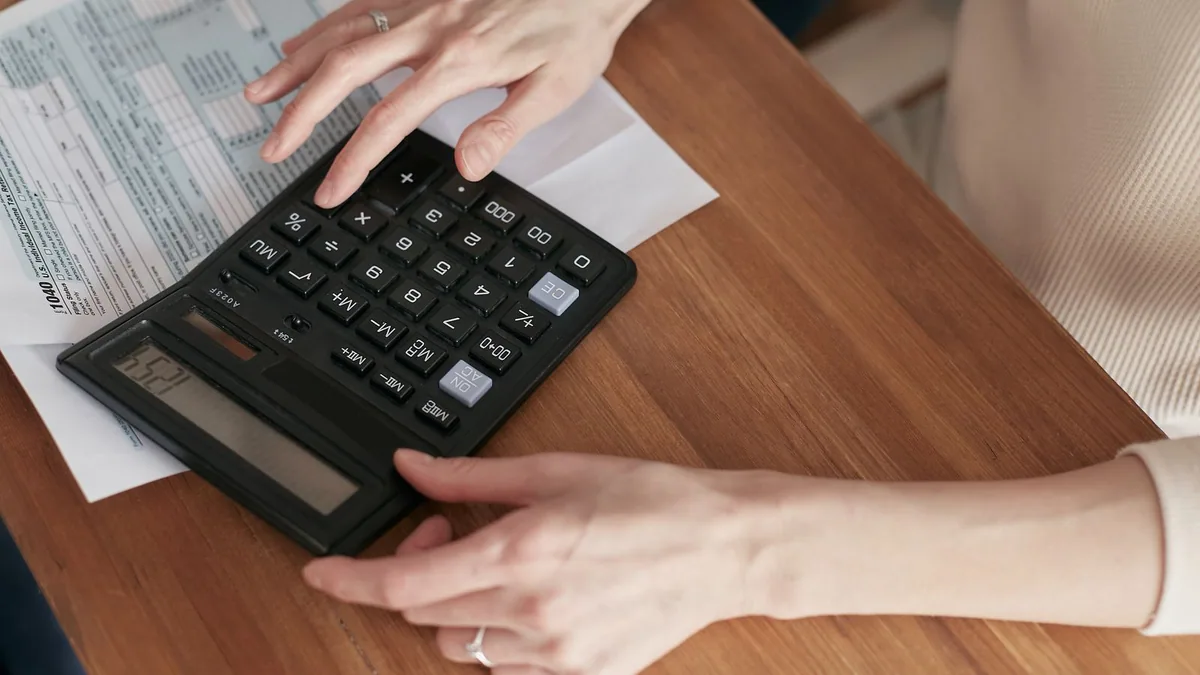 prix de revient : calcul des coûts avec une calculatrice sur un bureau