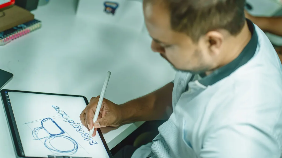 comment protéger son logo : graphiste dessinant un logo sur une tablette graphique