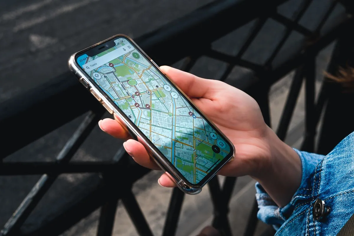 Référencement local : main tenant un smartphone affichant une application de carte