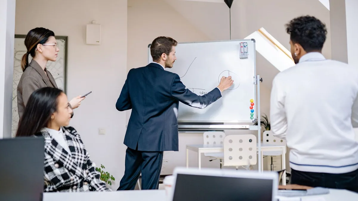 Référencement payant : une équipe commerciale analyse ses prospects devant un tableau blanc