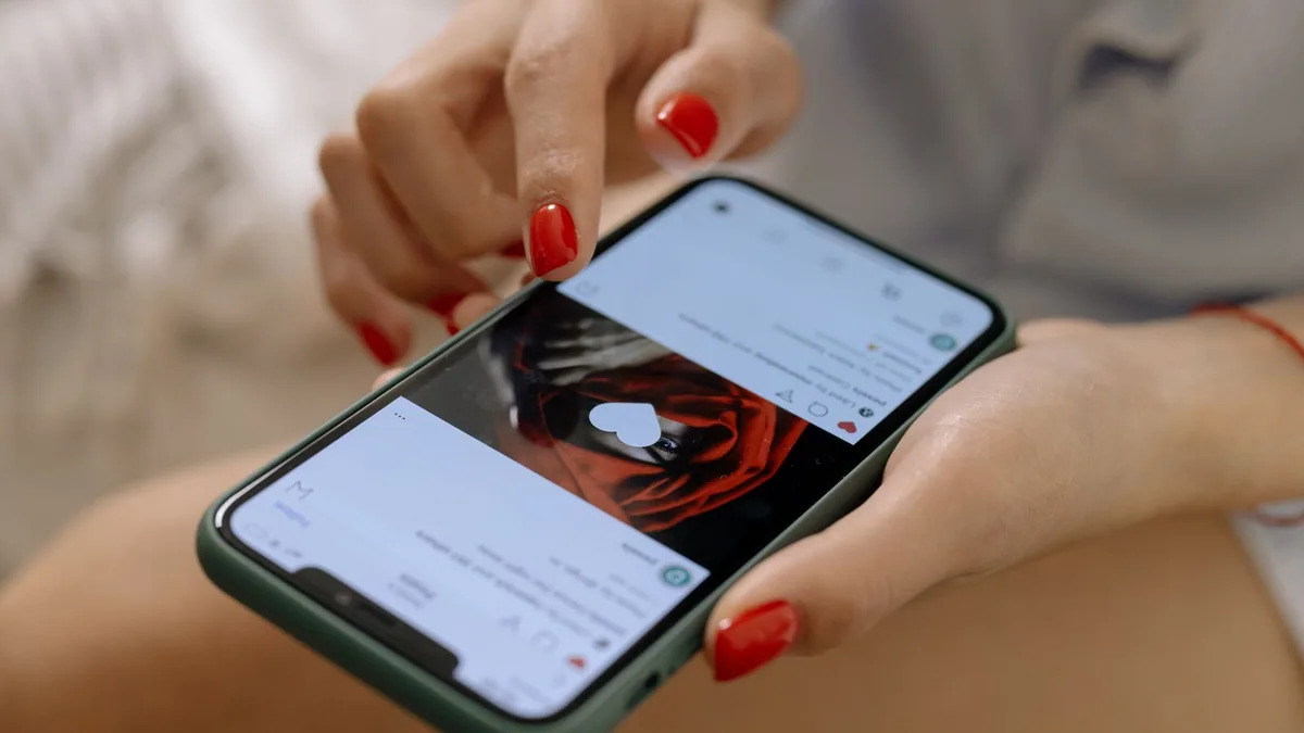 Référencement réseaux sociaux : une femme consulte un fil d'actualité sur son smartphone