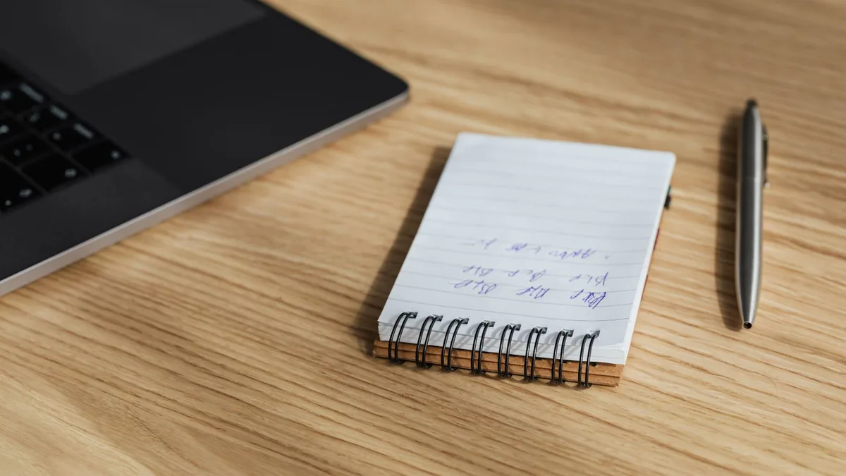 Référencement pas cher : carnet de notes et ordinateur pour travailler son SEO soi-même