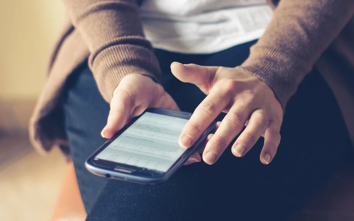 Rendre un site attractif : personne assise consultant un site sur son smartphone