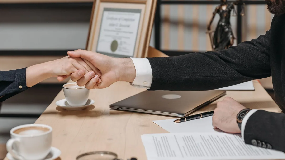 Social selling : poignée de main concluant un accord commercial après une prise de contact en ligne