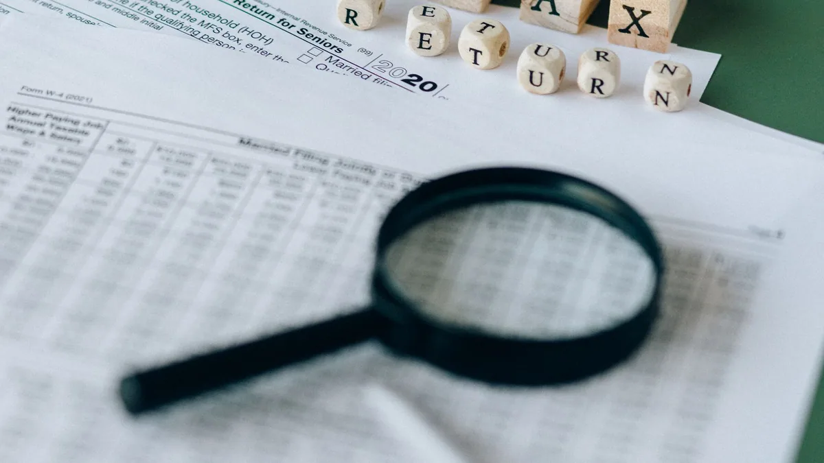 taux réduit IS : documents fiscaux examinés à la loupe sur un bureau