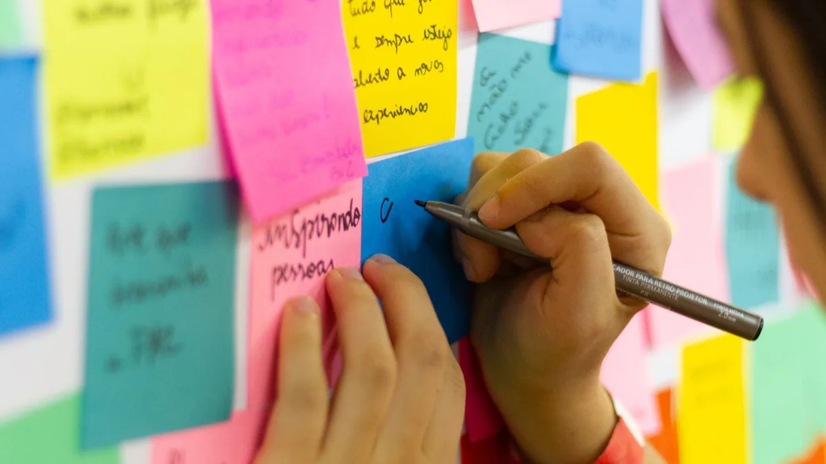 Trouver un nom de domaine : personne notant des idées de noms sur des notes adhésives