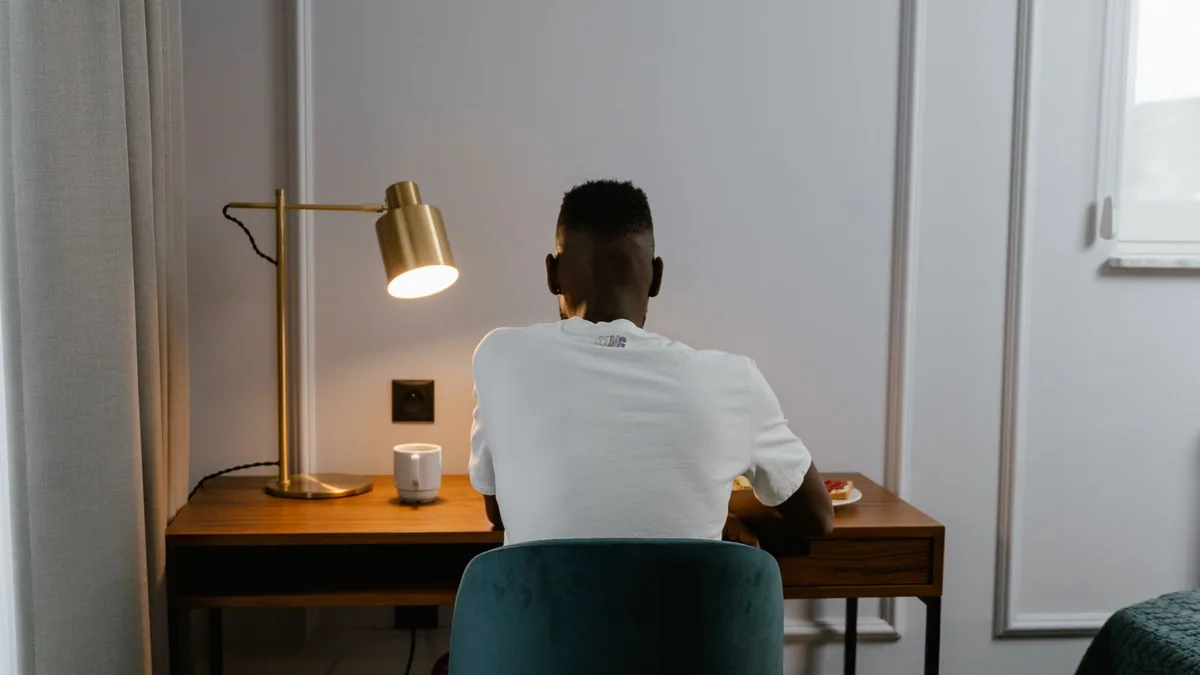 vie d'entrepreneur : dirigeant de dos travaillant seul à son bureau