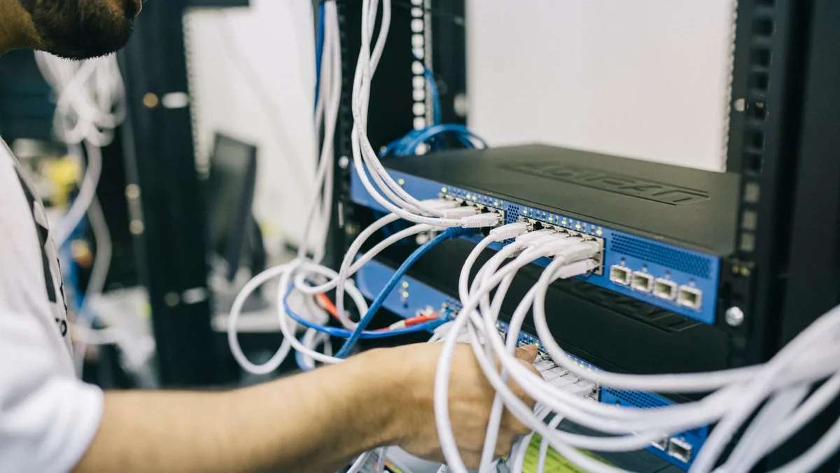 WordPress multisite : technicien vérifiant les câbles d'un serveur d'hébergement